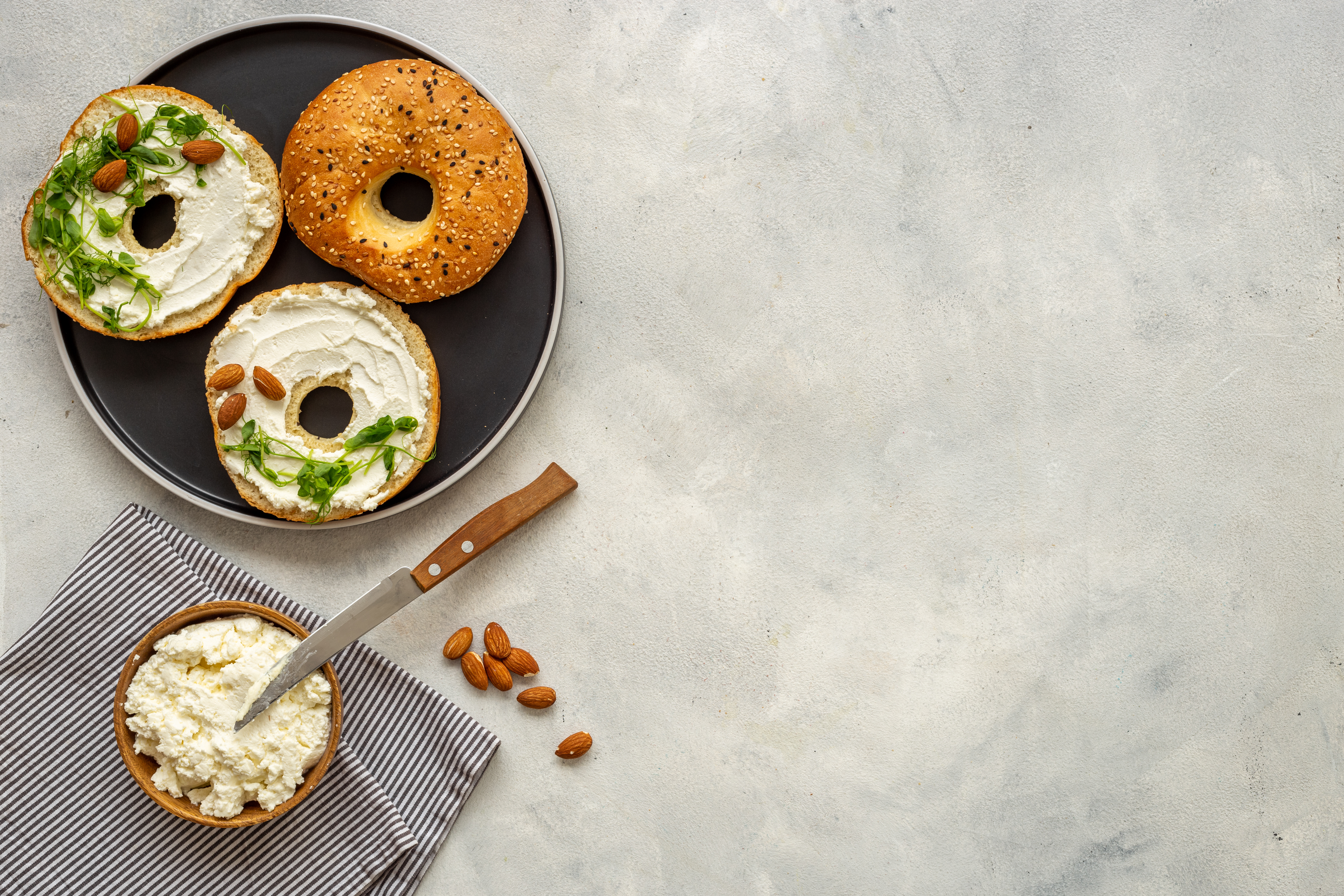 Homemade baked bread bagels with cheese cream. Healthy breakfast background.